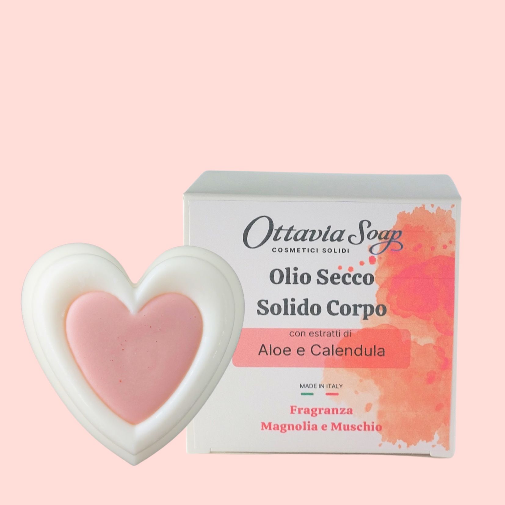Olio Secco Solido con estratti di Aloe e Calendula In primo piano un panetto bianco a forma di cuore ed in secondo piano la confezione con l’etichetta descrittiva