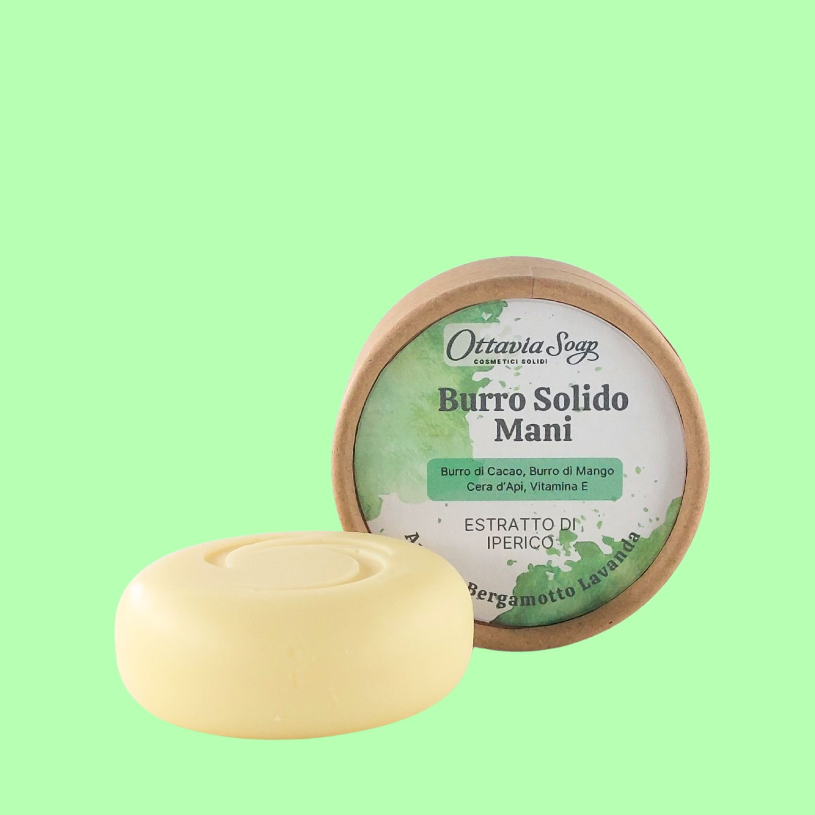 Burro solido con estratto di Iperico In primo piano un panetto chiaro e tondo. In secondo piano la confezione con l’etichetta descrittiva