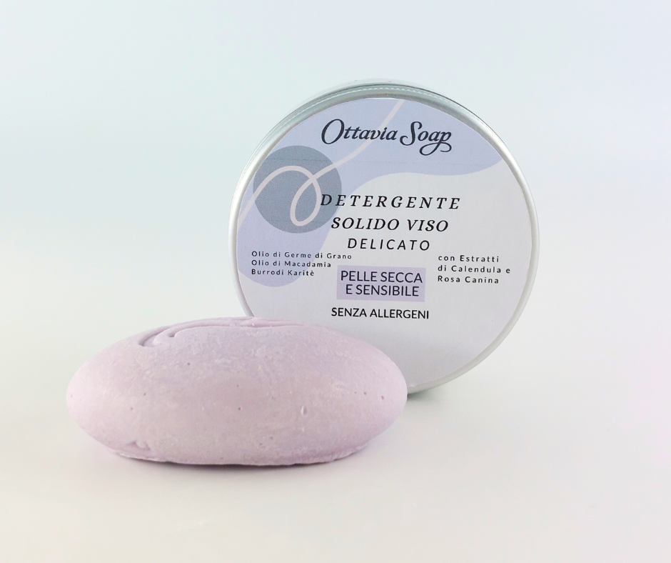 Detergente Solido Viso pelli Delicate e Secche In primo piano il detergente color viola e forma ovale ed in secondo piano un vasetto tondo in alluminio con l'etichetta delle informazioni
