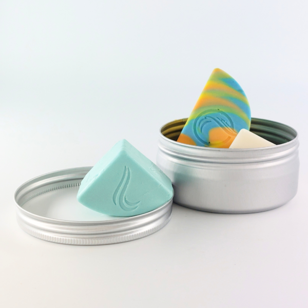 Scatola porta solidi aperta contenente shampoo, balsamo e sapone in formato da viaggio