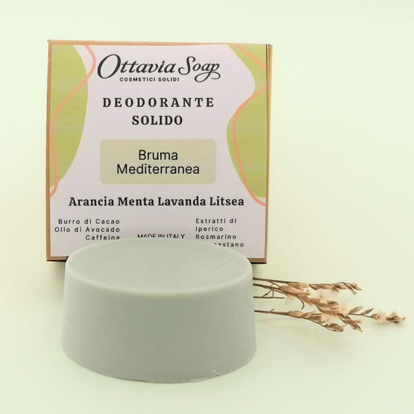 In primo piano un panetto ovale di deodorante solido color Verde Salvia. In secondo piano la confezione del deodorante con ii nome del prodotto e gli ingredienti in evidenza